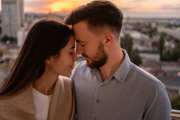 Homem e mulher na varanda ao pôr do sol na cidade — Fotografia de Stock