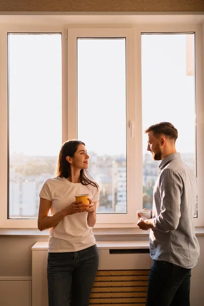 Чоловік і жінка п'ють чай біля вікна — стокове фото