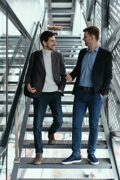 Due uomini che salgono, scendono le scale mentre chiacchierano — Foto Stock
