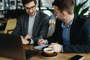 İki genç işadamı restoranda başarılı bir toplantı yapıyor..