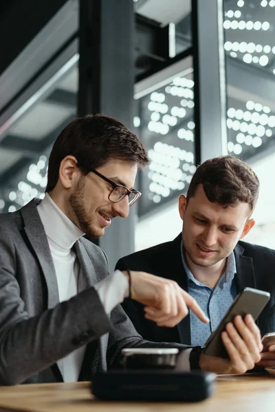 Due uomini d'affari che hanno una conversazione utilizzando uno smartphone — Foto Stock