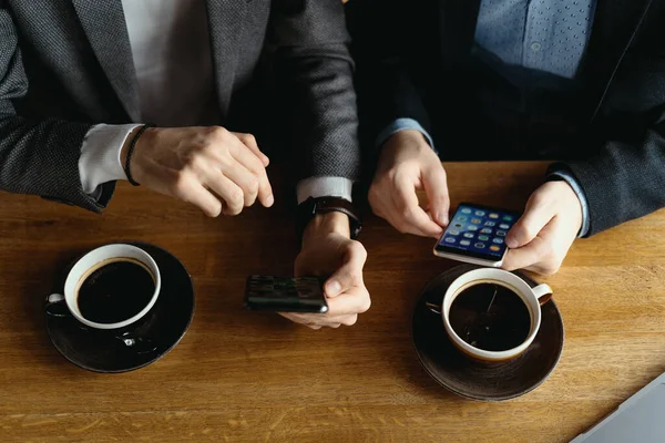 Due uomini d'affari che hanno una conversazione utilizzando uno smartphone — Foto Stock