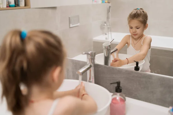 Маленькая девочка моет руки с мылом — стоковое фото