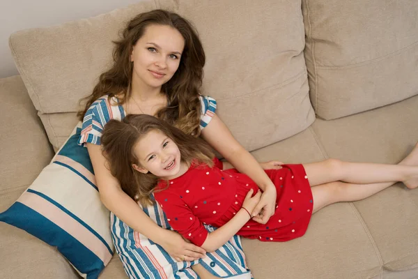 Портрет матери и дочери лежит на диване — стоковое фото