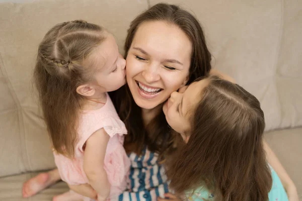 Две дочери целуют мамочку — стоковое фото
