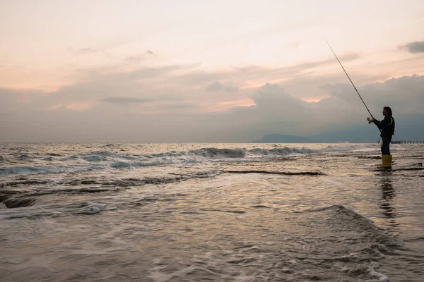 Человек рыбачит на берегу моря — стоковое фото