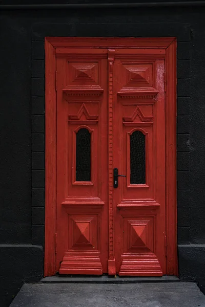 Puerta vintage roja sobre fondo de pared negro —  Fotos de Stock