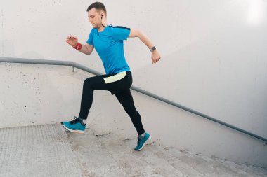 Genç adam merdivenlerde antrenman yapıyor.