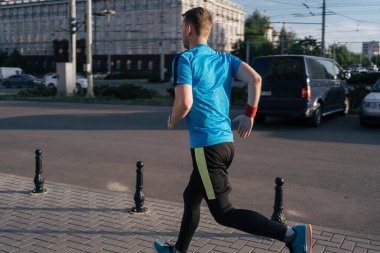 Şehirde koşan çekici fit bir adam.