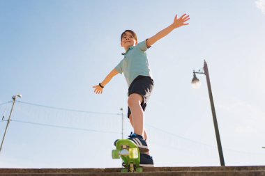 Sokakta kaykay süren bir çocuk.