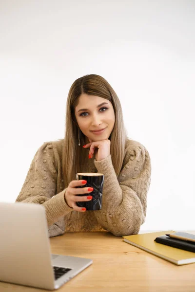 Young female at cafe using laptop and drinking latte — Stock Photo, Image