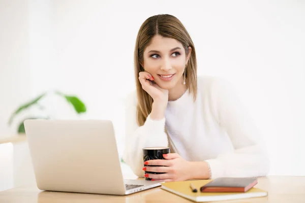 Smiling caucasian woman working on laptop — Stock Photo, Image