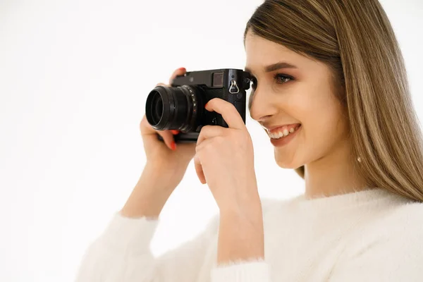 Sorrindo mulher segurando câmera no fundo branco — Fotografia de Stock