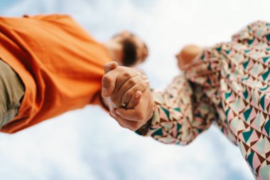 Gökyüzü arka planındaki mutlu çift