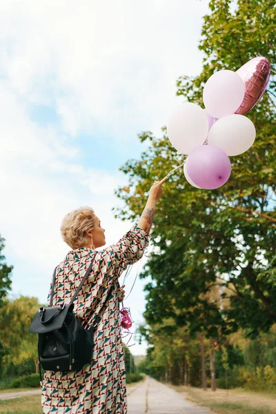 Mujer rubia con globos rosados — Foto de Stock