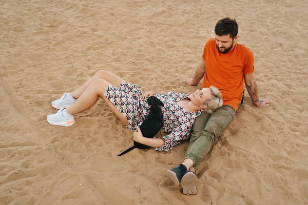 Preciosa pareja disfrutar el uno del otro sentado en la arena —  Fotos de Stock