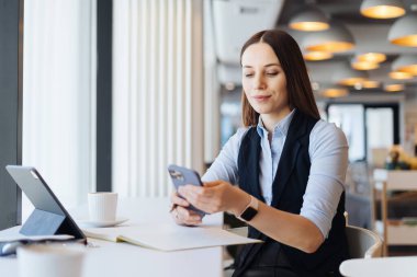 Kafkasyalı güzel bir kadın iş için akıllı telefon kullanıyor.