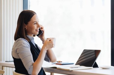 Kafkasyalı güzel bir kadın iş için akıllı telefon kullanıyor.