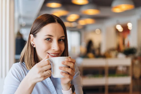 Retrato de jovem bebendo café à mesa no café — Fotografia de Stock