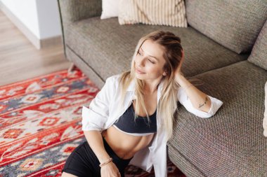 Stressiz bir hafta sonu, sakin bir kız kanepede uzanıyor ve keyifli bir tembel günü düşünüyor.