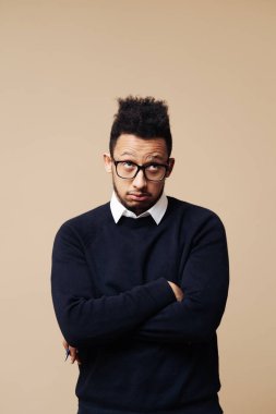 Bej arka planda düşünen genç bir afro adam