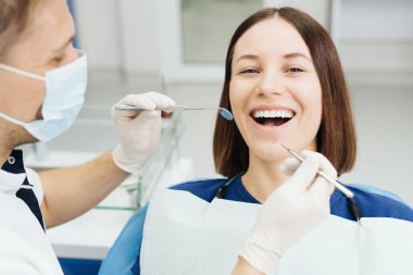 Dişçi, klinikteki aletleri kullanarak hasta boşluğunu kontrol ediyor.