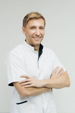 Gülümseyen doktor kameraya, sağlık hizmetine ve tıbba poz veriyor ve gülümsüyor