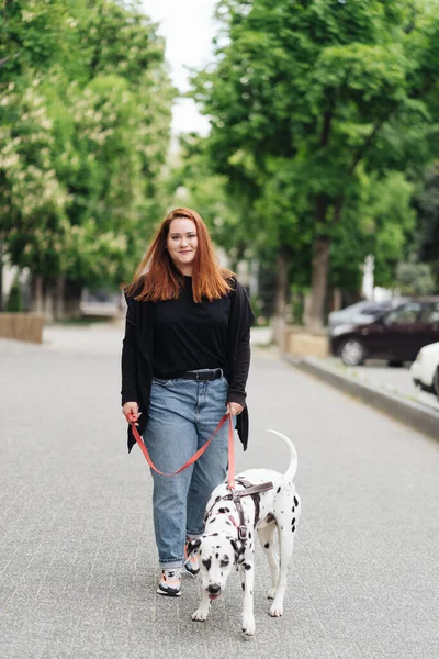 Kobieta spacerująca, dyskutująca i bawiąca się swoim dalmatyńskim zwierzakiem w mieście — Zdjęcie stockowe