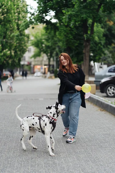 Kobieta dyskutująca i szkoląca swojego dalmatyńskiego zwierzaka w mieście — Zdjęcie stockowe
