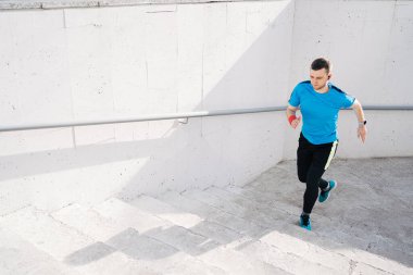 Genç adam merdivenlerde antrenman yapıyor.
