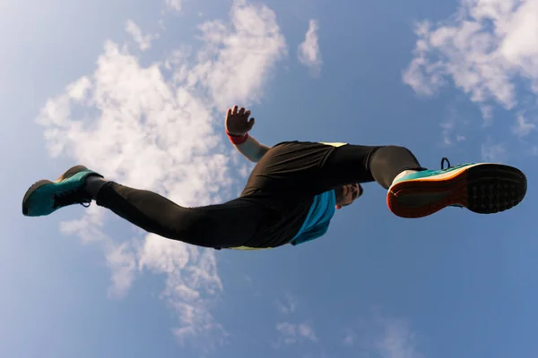 Sportovec běží a vyskočí do nebe — Stock fotografie