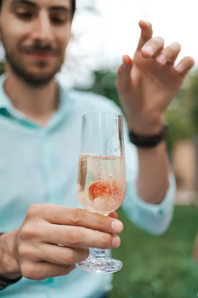 Man hand holding a glass with sparkling wine — Stock Photo, Image