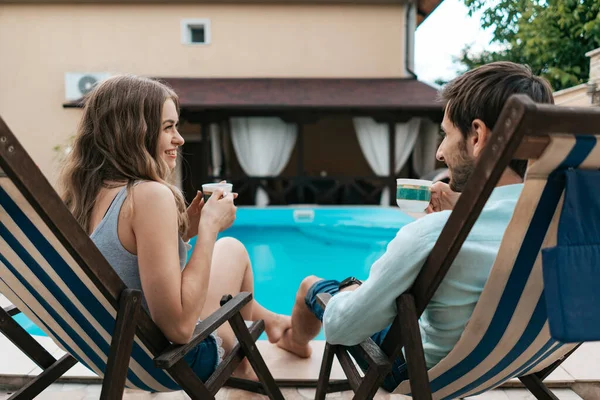 Hombre y mujer pasan tiempo juntos cerca de la piscina tomando té — Foto de Stock