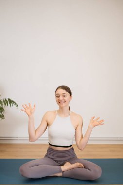 İçeride yoga yapan güzel bir genç kadının portresi.