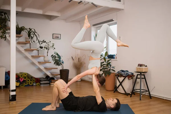 Pareja deportiva practicando yoga juntos en casa — Foto de Stock