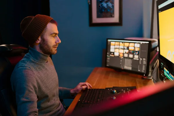 Editor de vídeo masculino trabalhando em seu computador pessoal com grande exibição — Fotografia de Stock