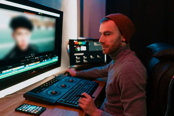Editor de vídeo masculino trabalhando em seu computador pessoal com grande exibição — Fotografia de Stock