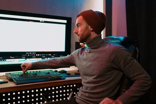 Editor video maschile che lavora sul suo personal computer con grande display vuoto — Foto Stock