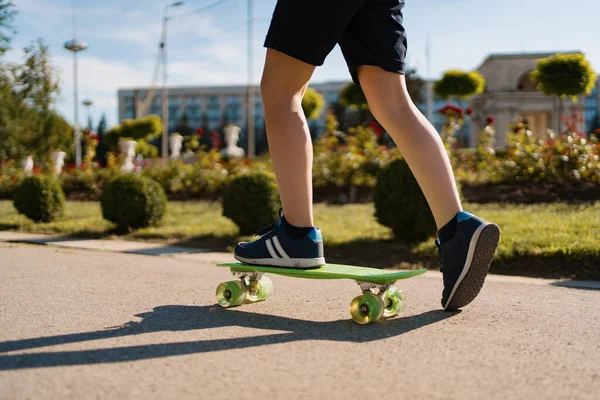 Feche os pés do skatista enquanto patina no parque — Fotografia de Stock