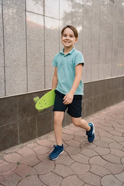 A little boy holds a GREEN penny in his hands while walking — Stock Photo, Image