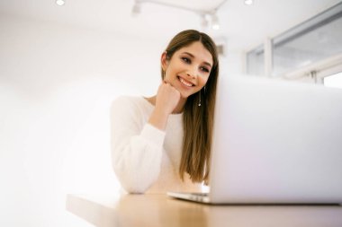 Diz üstü bilgisayarında sosyal ağlarda arkadaşlarıyla sohbet ederken gülen mutlu bir blog yazarı