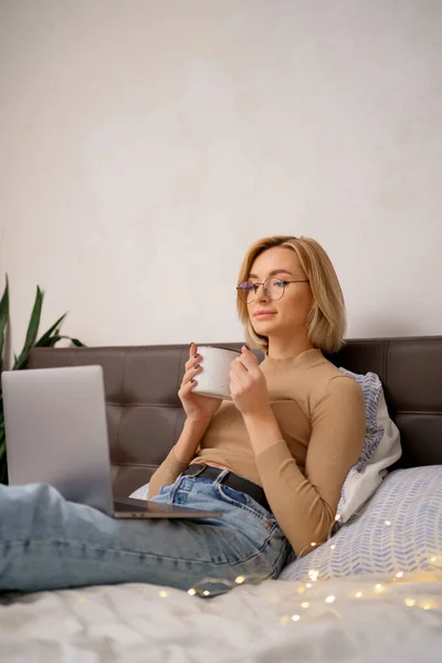Donna con gli occhiali che controlla le app sociali e lavora. — Foto Stock