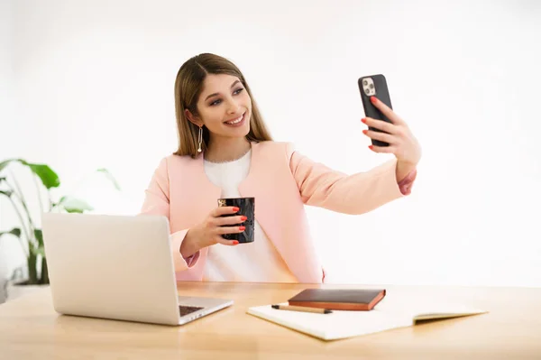 Mulher sorridente usando o smartphone dentro de casa — Fotografia de Stock