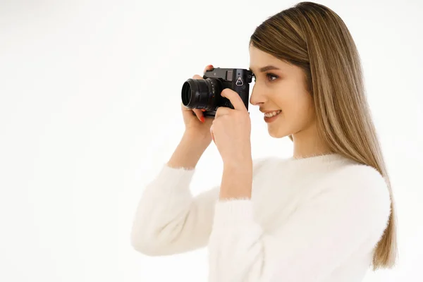 Усміхнена жінка тримає камеру на білому тлі — стокове фото
