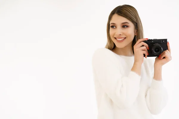 Sorrindo mulher segurando câmera no fundo branco — Fotografia de Stock