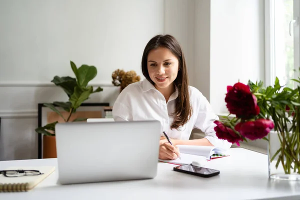 Empresária trabalhando no computador portátil sentado em casa e gerenciando seu negócio via home office — Fotografia de Stock