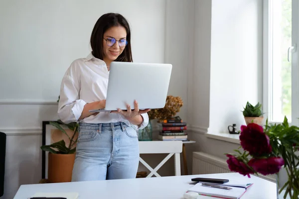 Empresária trabalhando no computador portátil sentado em casa e gerenciando seu negócio via home office — Fotografia de Stock