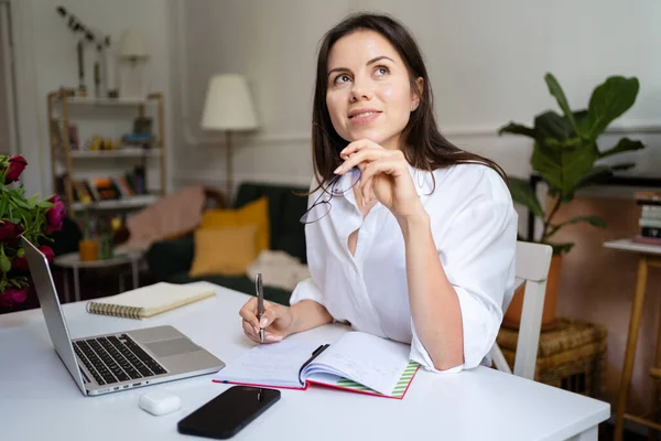 Femme d'affaires travaillant sur ordinateur portable assis à la maison et la gestion de son entreprise via le bureau à domicile — Photo