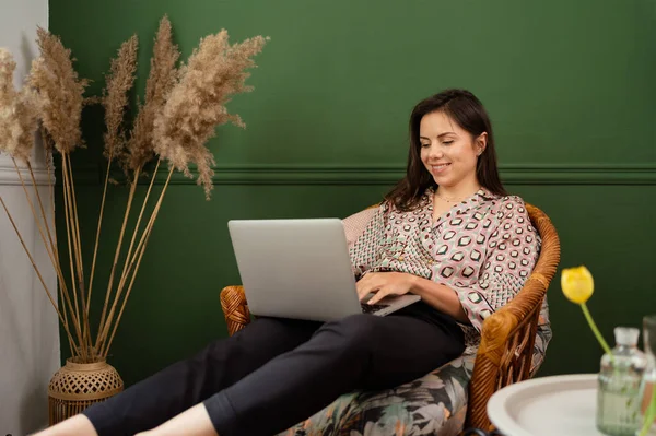 在笔记本电脑上工作的女商人坐在家里，通过总公司管理她的生意 — 图库照片