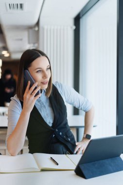 Kafkasyalı güzel bir kadın iş için akıllı telefon kullanıyor.